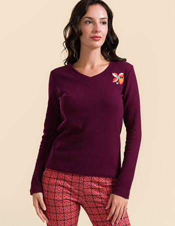 Model draagt Lalamour Kelly longsleeve bordeaux met wafelstructuur en bloemdetai