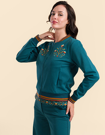 Model draagt Lalamour Nora bomberjack petrol met geborduurde bloemen op de borst