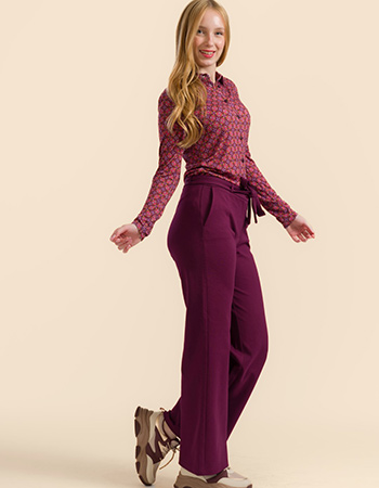 Model draagt Lalamour Sue pantalon bordeaux met strikceintuur – biologisch katoe