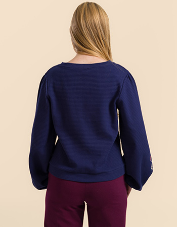 Model draagt Lalamour Cathy top blauw met wafelstructuur en geborduurde mouwen –