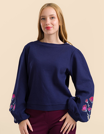 Model draagt Lalamour Cathy top blauw met wafelstructuur en geborduurde mouwen –