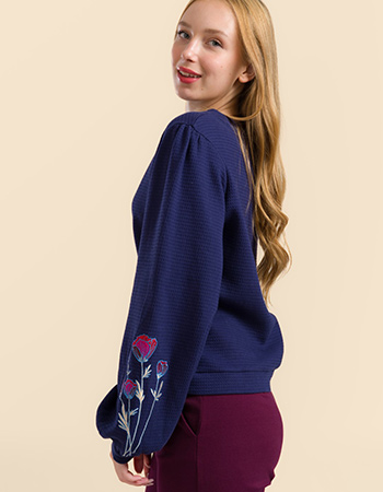 Model draagt Lalamour Cathy top blauw met wafelstructuur en geborduurde mouwen –