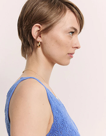 Gebreide dames top met V-hals en verfijnd opengewerkt motief.