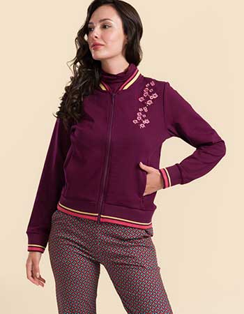 Model draagt Lalamour Nora bomberjack bordeaux met geborduurde bloemen op de sch