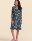 Model draagt Lalamour Chrissy Cross jurk groen met Birdy bloemen en vogelprint –